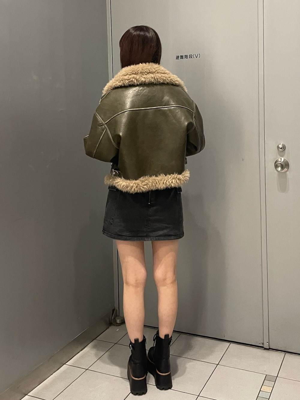 ブラック系のスカート、グリーン系のムートンコート、その他のTシャツ/カットソーを着用したレディースの夏コーディネートの4枚目の写真