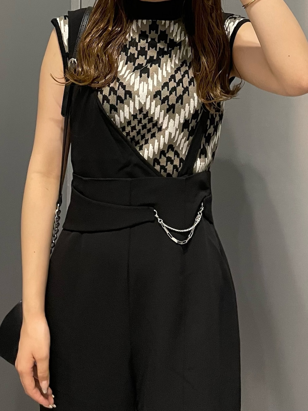 ブラウン系のニット/セーター、ブラック系のスラックス、ブラック系のハンドバッグを着用したレディースの夏コーディネートの6枚目の写真