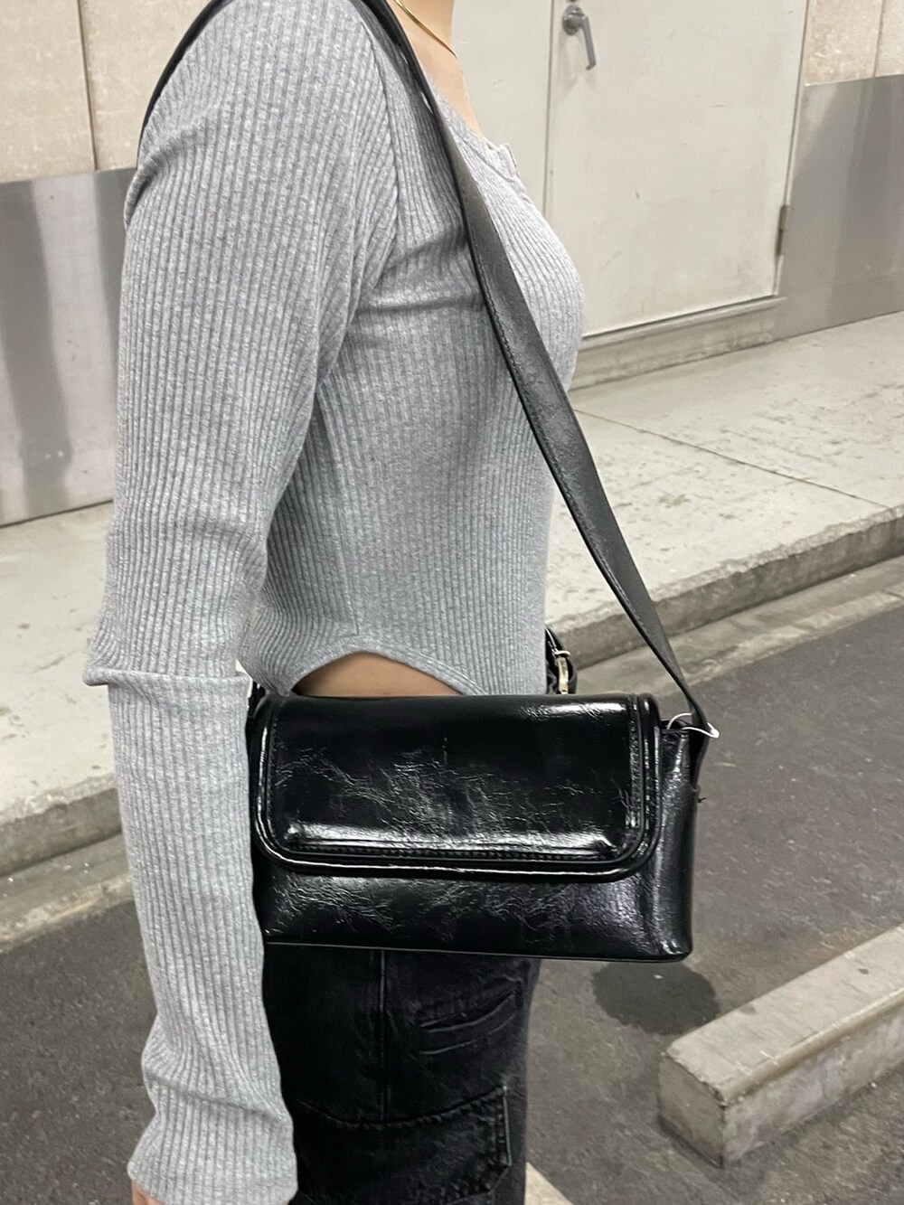 ブラック系のデニムパンツ、ブラック系のショルダーバッグ、グレー系のTシャツ/カットソーを着用したレディースの冬コーディネートの9枚目の写真