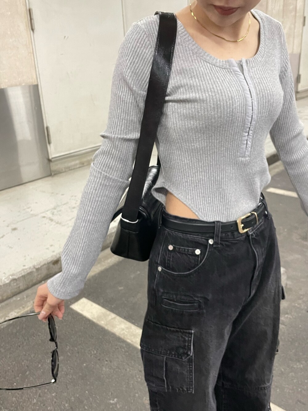 ブラック系のデニムパンツ、ブラック系のショルダーバッグ、グレー系のTシャツ/カットソーを着用したレディースの冬コーディネートの6枚目の写真