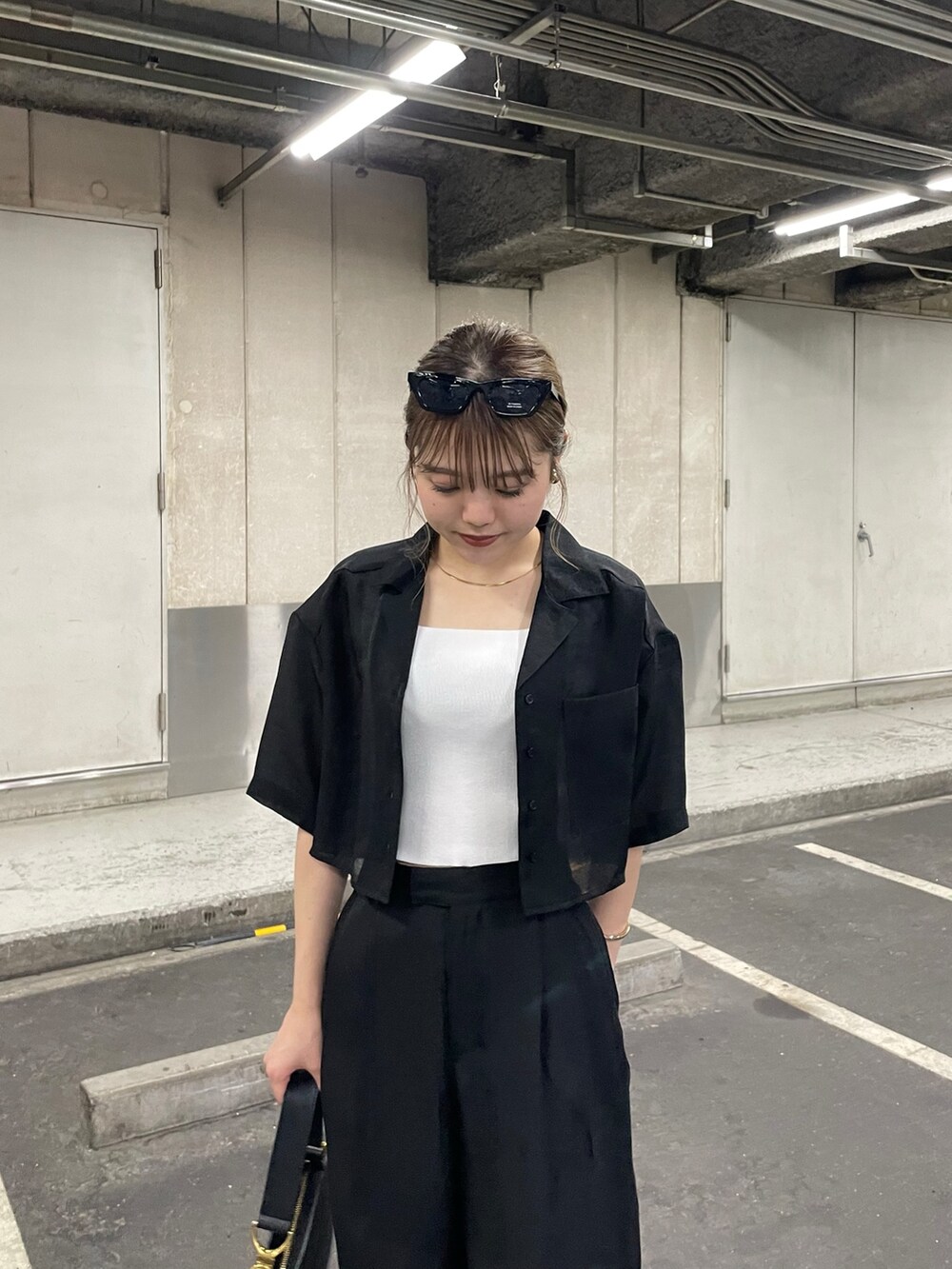 ブラック系のブーツ、ブラック系のその他パンツ、ホワイト系のニット/セーターを着用したレディースの夏コーディネートの5枚目の写真