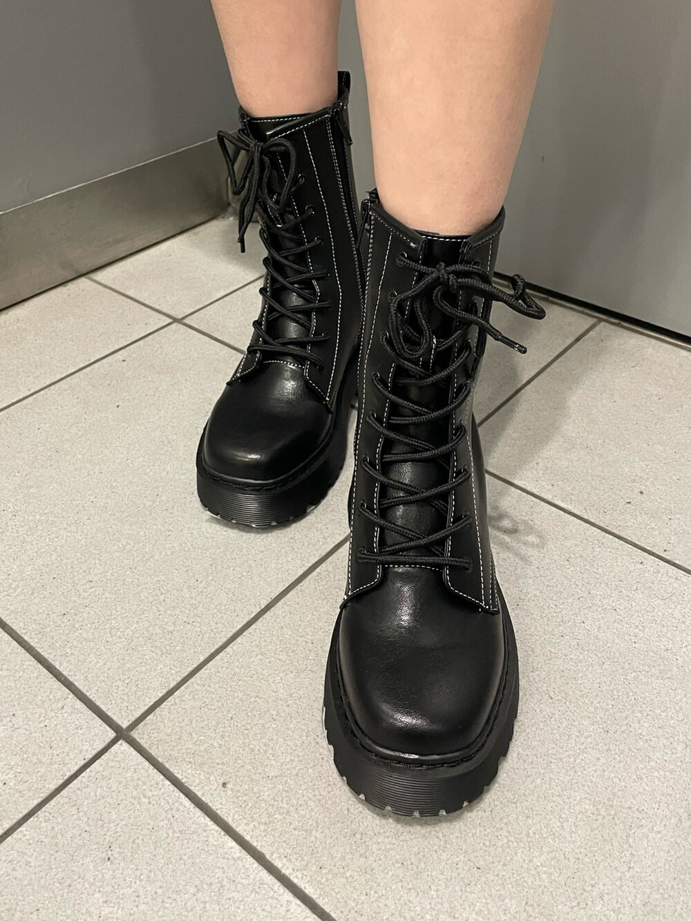 ブラック系のブーツ、グレー系のスカート、グレー系のTシャツ/カットソーを着用したレディースの冬コーディネートの7枚目の写真