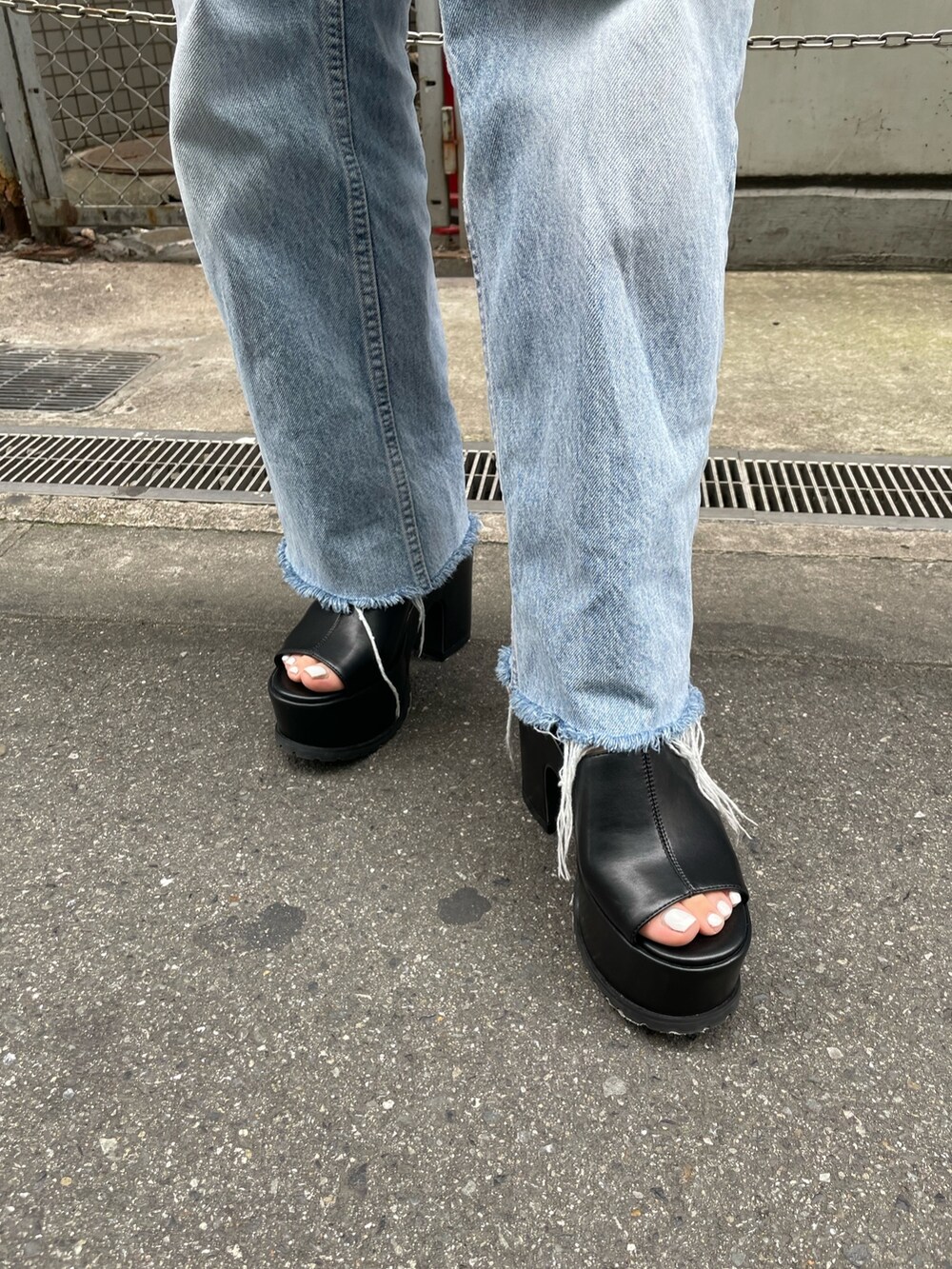 ブラック系のニット/セーター、シルバー系のハンドバッグ、ブラック系のサンダルを着用したレディースの春コーディネートの6枚目の写真