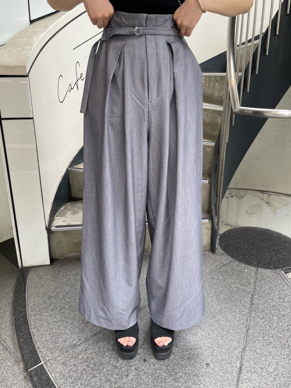 ブラック系のニット/セーター、ブラック系のショルダーバッグ、グレー系のその他パンツを着用したレディースの春コーディネートの7枚目の写真