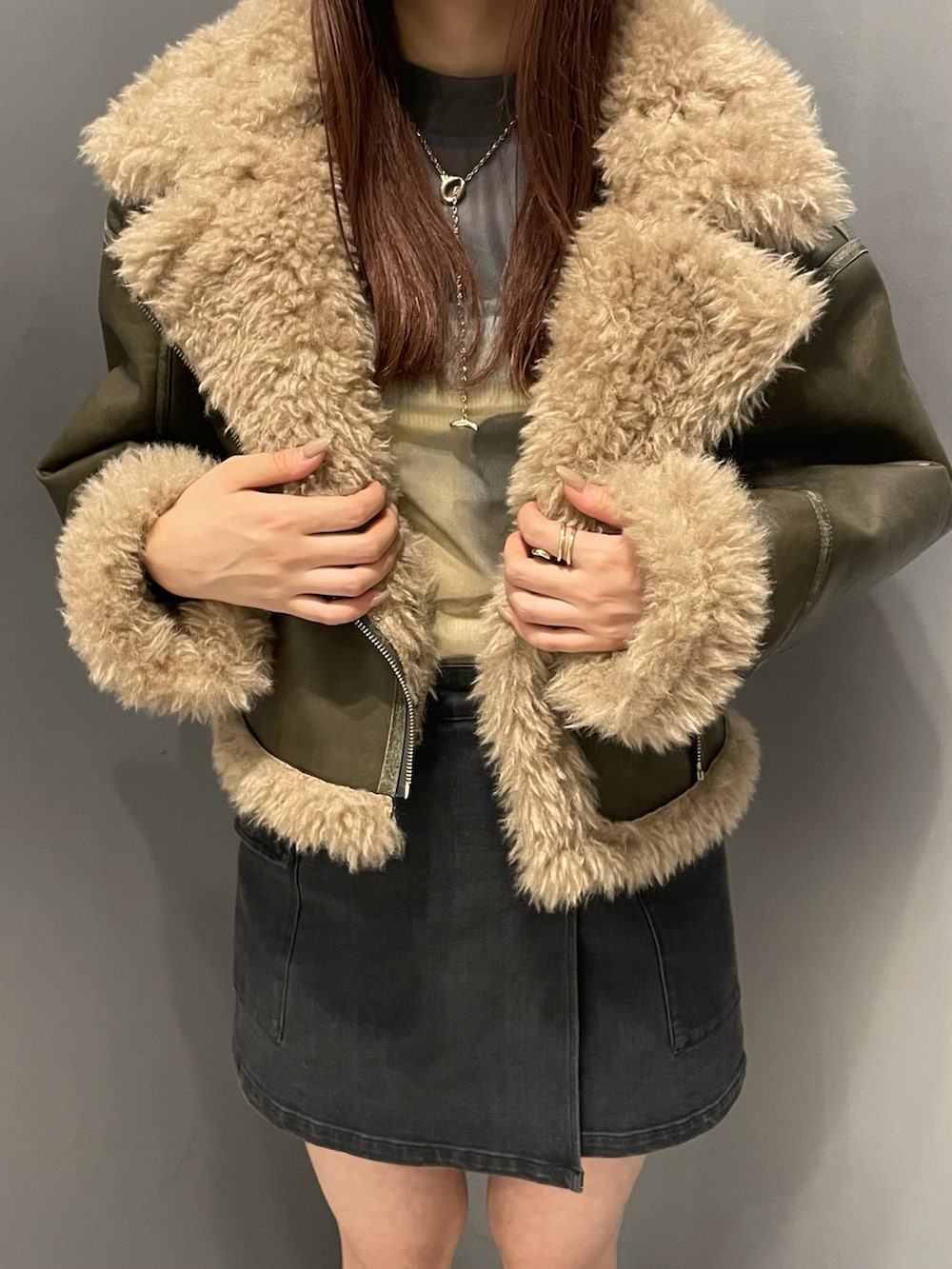 ブラック系のスカート、グリーン系のムートンコート、その他のTシャツ/カットソーを着用したレディースの夏コーディネートの6枚目の写真