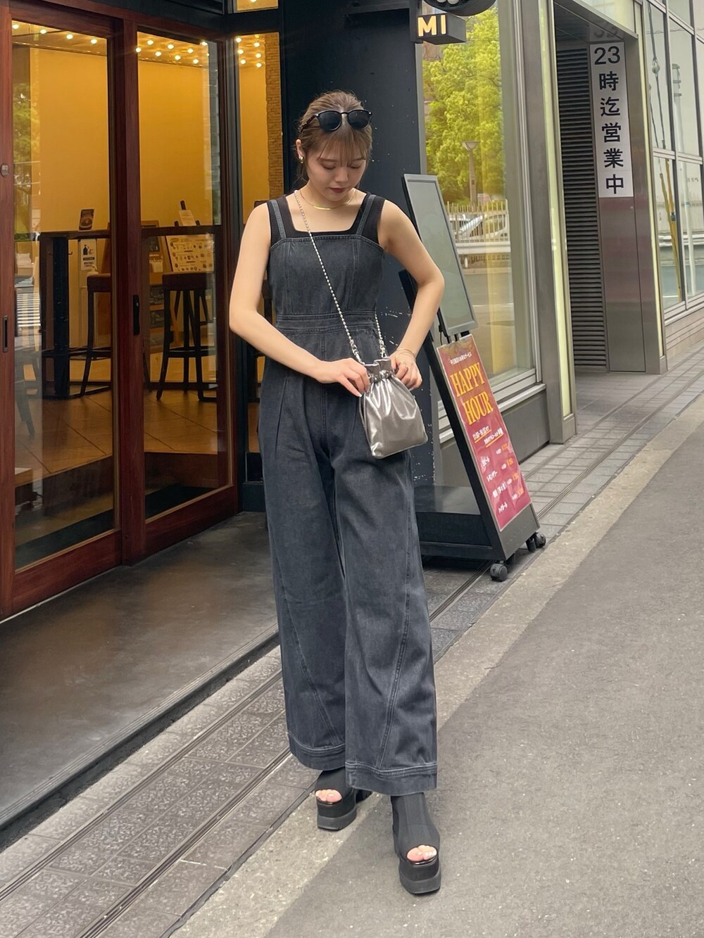 グレー系のショルダーバッグ、ブラック系のブーツ、ブラック系のニット/セーターを着用したレディースの春コーディネートの3枚目の写真