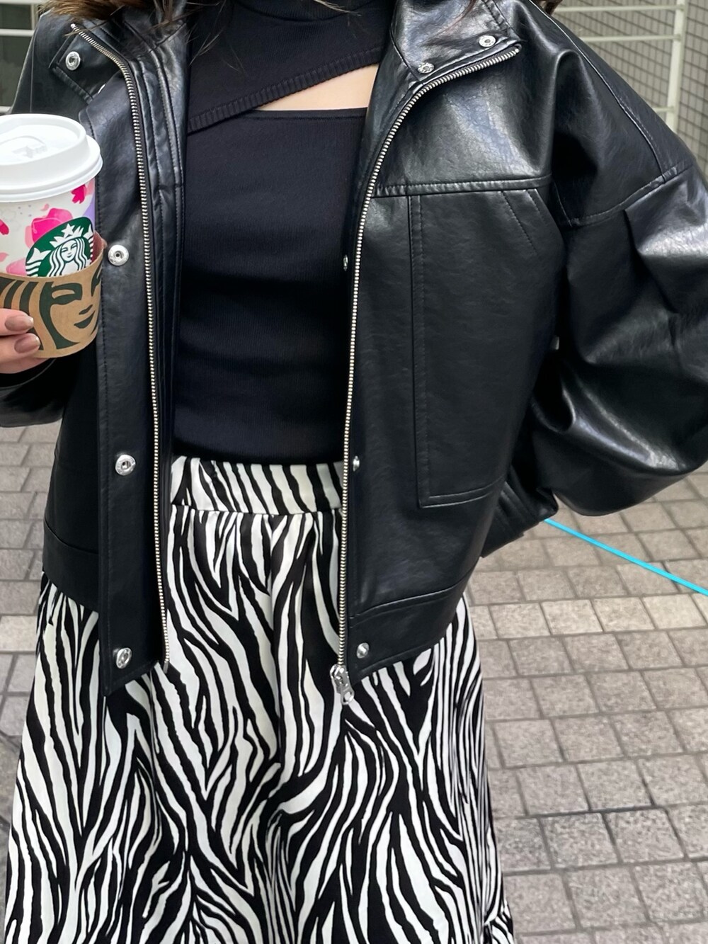 ブラック系のブルゾン、ホワイト系のスカート、ブラック系のニット/セーターを着用したレディースの春コーディネートの7枚目の写真