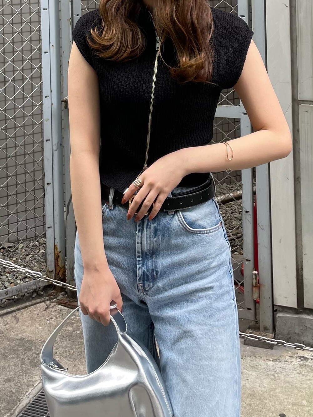 ブラック系のニット/セーター、シルバー系のハンドバッグ、ブラック系のサンダルを着用したレディースの春コーディネートの5枚目の写真