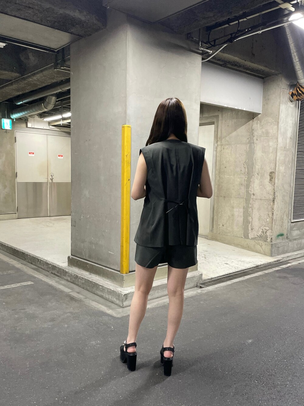 ブラック系のサンダル、ホワイト系のタンクトップ、グレー系のテーラードジャケットを着用したレディースの春コーディネートの3枚目の写真