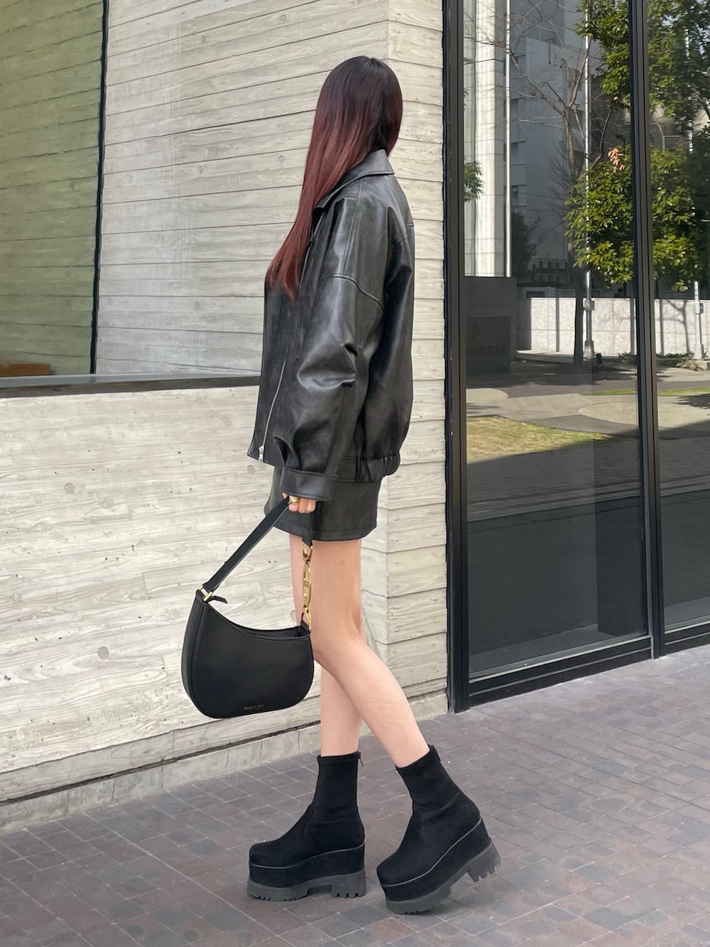 ブラック系のブルゾン、ブラック系のスカート、ホワイト系のニット/セーターを着用したレディースの冬コーディネートの2枚目の写真