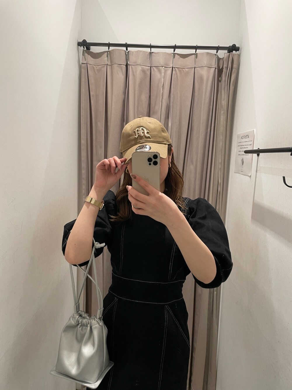 ブラック系のブーツ、ブラック系のワンピース、シルバー系のハンドバッグを着用したレディースの春コーディネートの4枚目の写真