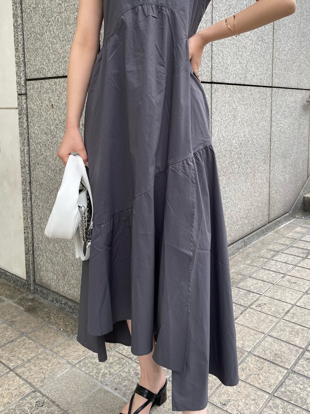 グレー系のワンピース、ブルー系のニット/セーター、ホワイト系のハンドバッグを着用したレディースの春コーディネートの5枚目の写真