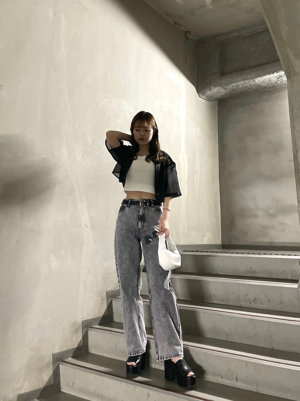 ホワイト系のTシャツ/カットソー、グレー系のデニムパンツ、ブラック系のサンダルを着用したレディースの春コーディネートの2枚目の写真