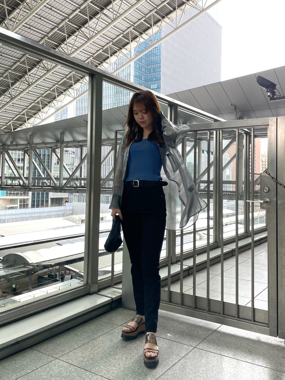 グレー系のシャツ/ブラウス、ブルー系のタンクトップ、ブラック系のハンドバッグを着用したレディースの春コーディネートの2枚目の写真