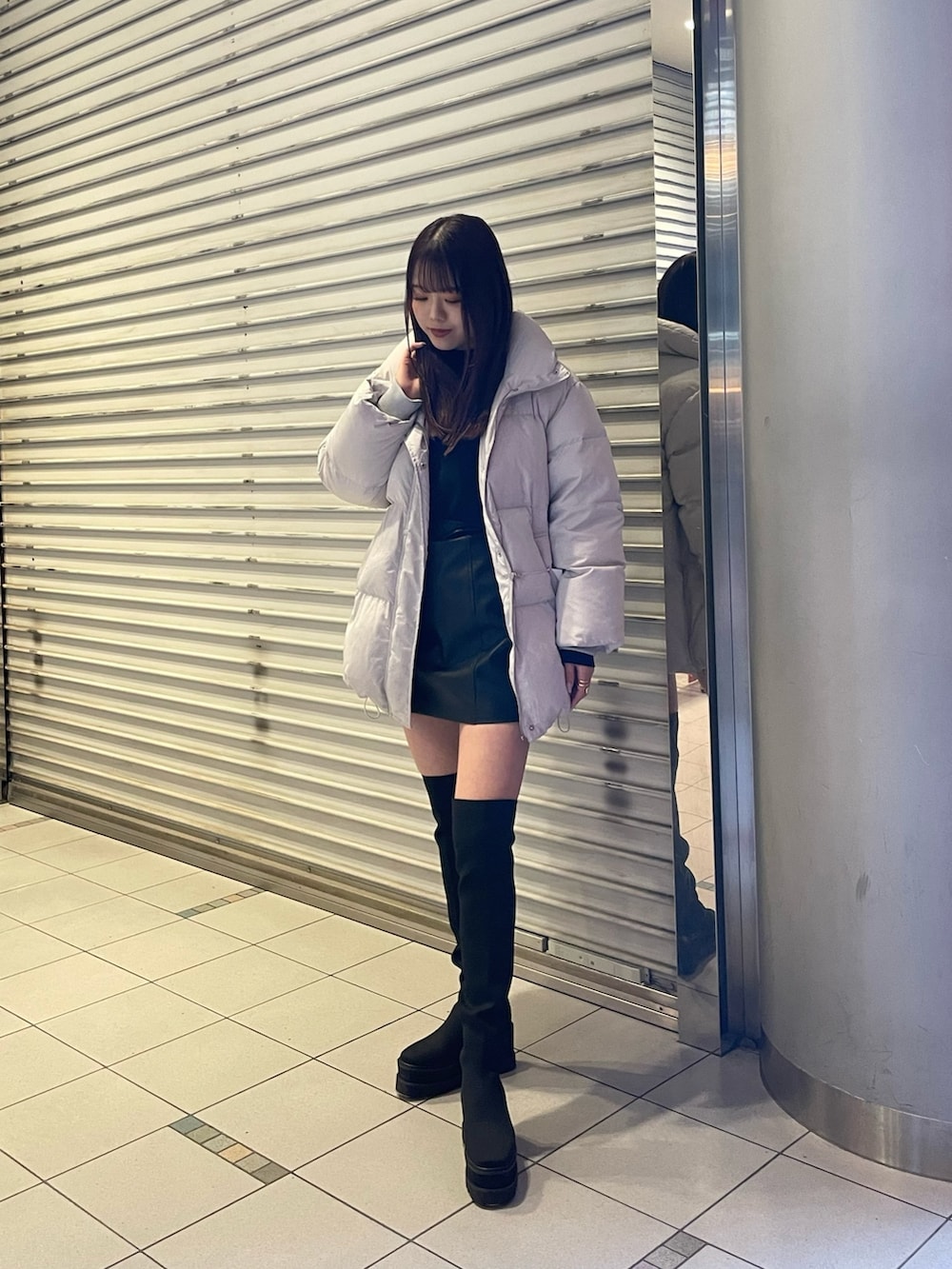 ブラック系のブーツ、ブラック系のニット/セーター、グレー系のダウンジャケット/コートを着用したレディースの冬コーディネートの2枚目の写真