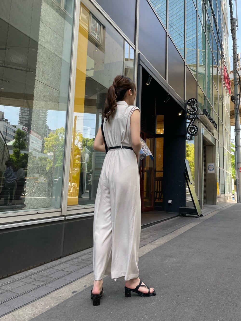 ホワイト系のつなぎ/オールインワン、ブラック系のサンダル、ブラック系のショルダーバッグを着用したレディースの春コーディネートの3枚目の写真