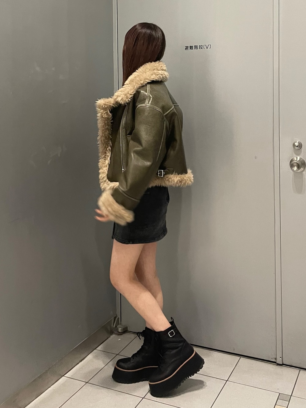 ブラック系のスカート、グリーン系のムートンコート、その他のTシャツ/カットソーを着用したレディースの夏コーディネートの3枚目の写真