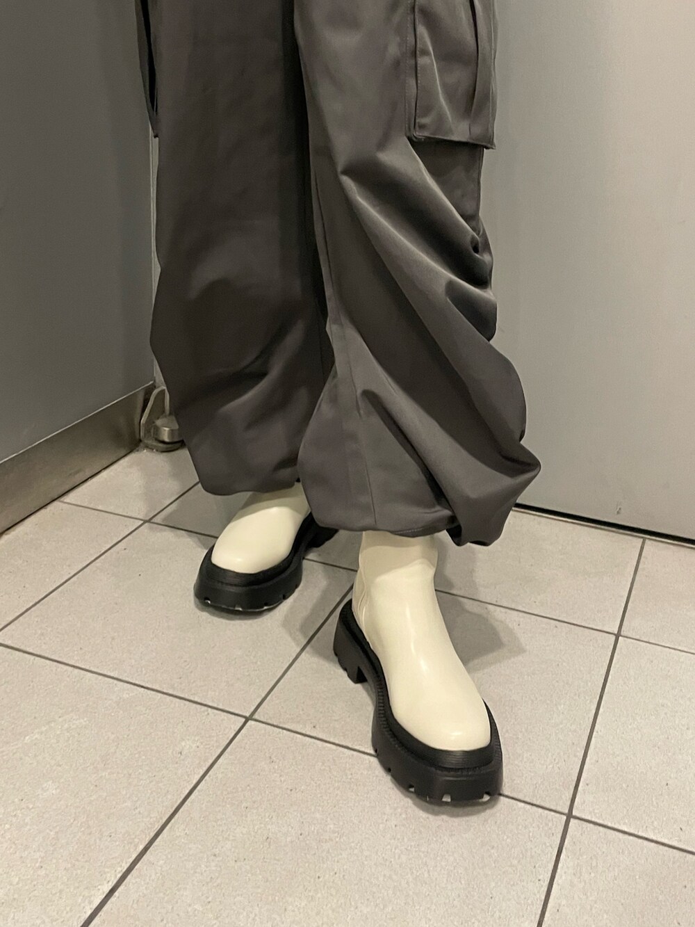 ブラック系のニット/セーター、グレー系のカーゴパンツ、ホワイト系のブーツを着用したレディースの冬コーディネートの8枚目の写真