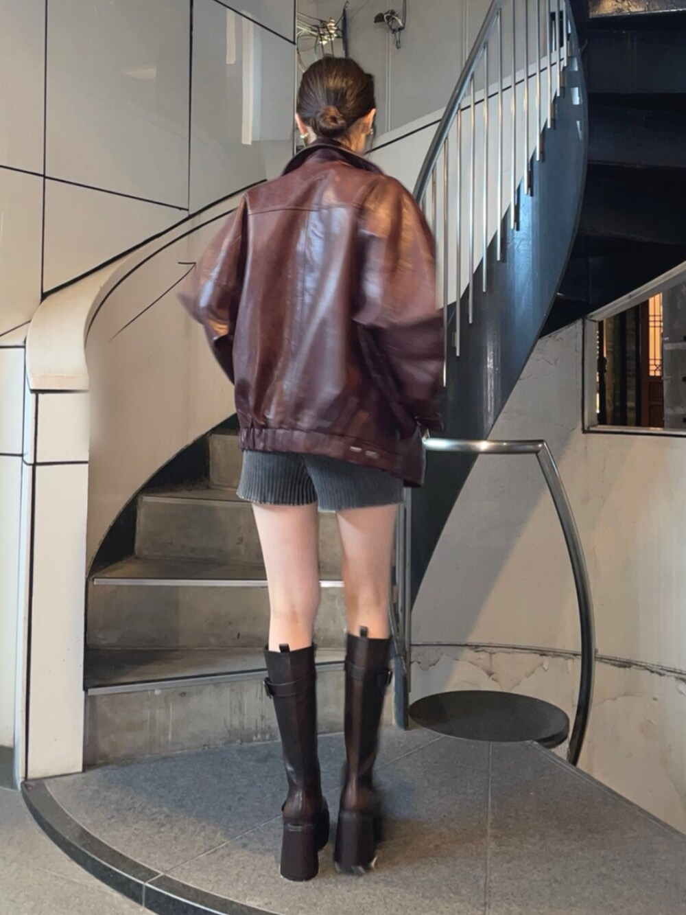 ブラック系のキャミソール、レッド系のブルゾン、ブラウン系のブーツを着用したレディースの夏コーディネートの3枚目の写真