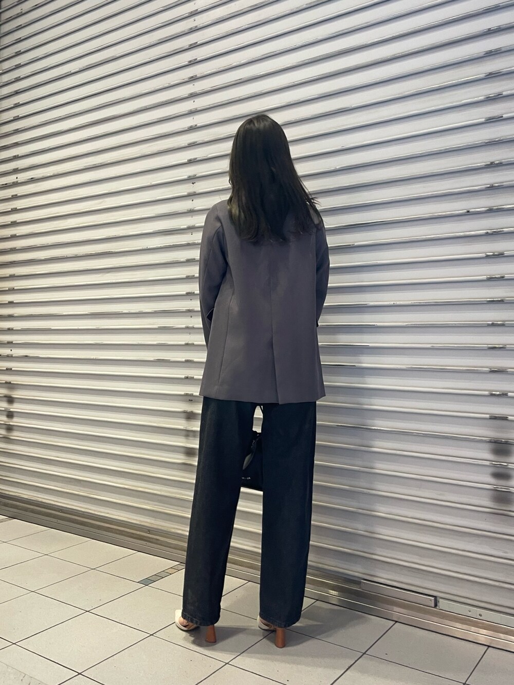 ブラック系のデニムパンツ、グレー系のテーラードジャケット、ホワイト系のニット/セーターを着用したレディースの冬コーディネートの3枚目の写真