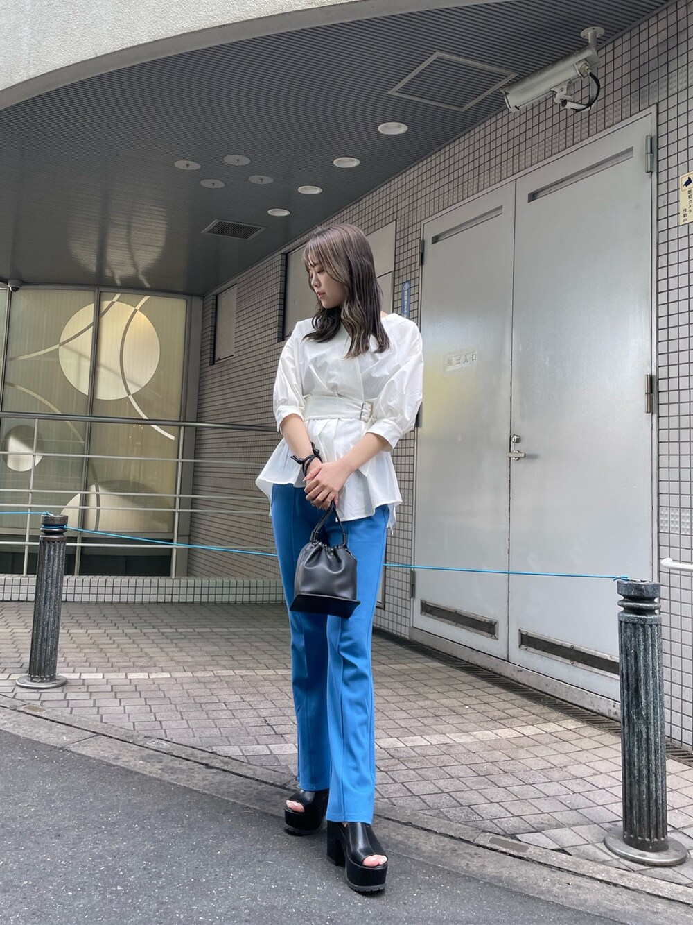 ホワイト系のシャツ/ブラウス、ブルー系のスウェットパンツ、ブラック系のハンドバッグを着用したレディースの春コーディネートの2枚目の写真