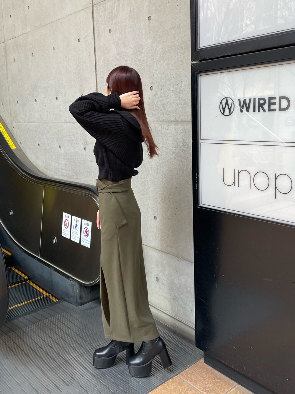 ブラック系のブーツ、グリーン系のスカート、ブラック系のニット/セーターを着用したレディースの冬コーディネートの3枚目の写真