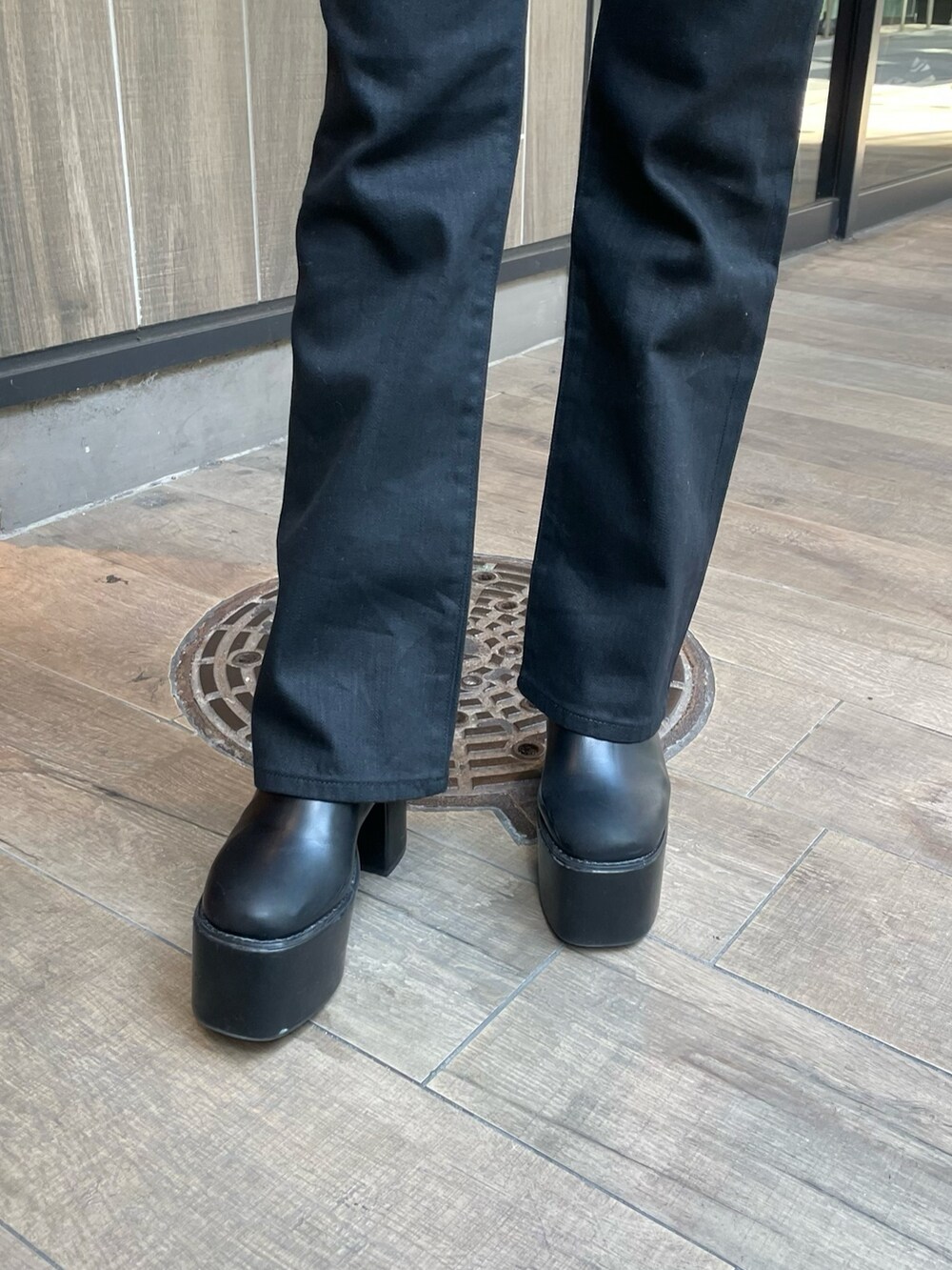 ブラック系のデニムパンツ、ブラック系のカーディガン/ボレロ、ブラック系のブーツを着用したレディースの秋コーディネートの8枚目の写真