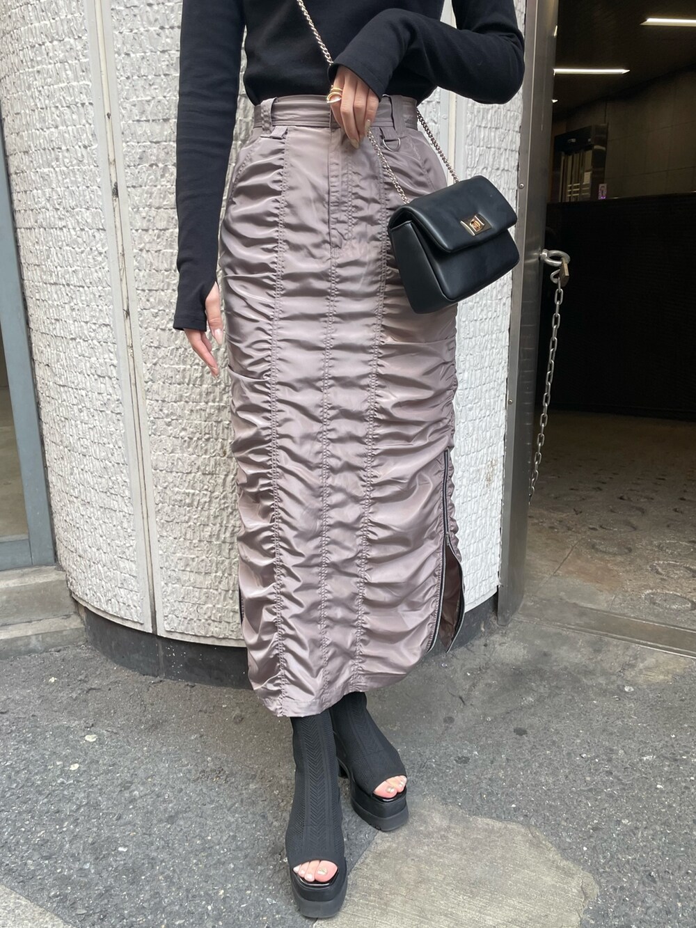 ブラック系のブーツ、グレー系のスカート、ブラック系のTシャツ/カットソーを着用したレディースの春コーディネートの6枚目の写真