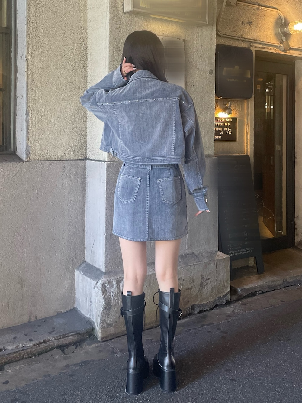 グレー系のスカート、ブラック系のブーツ、ブラック系のTシャツ/カットソーを着用したレディースの夏コーディネートの3枚目の写真