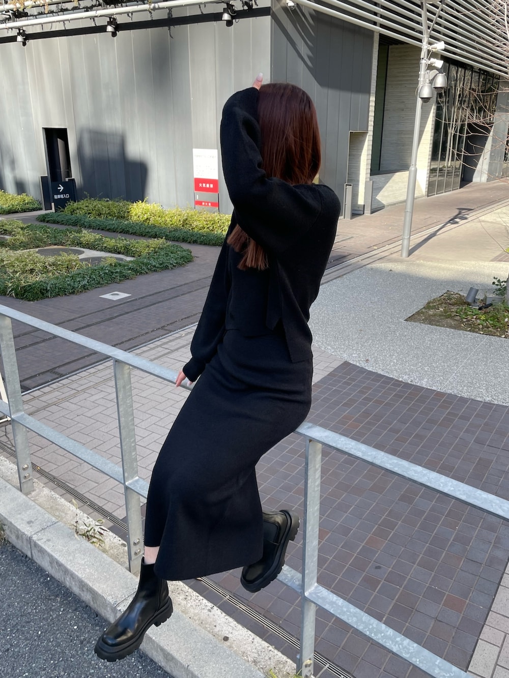 ブラック系のニット/セーター、ブラック系のスカート、ブラック系のブーツを着用したレディースの冬コーディネートの4枚目の写真