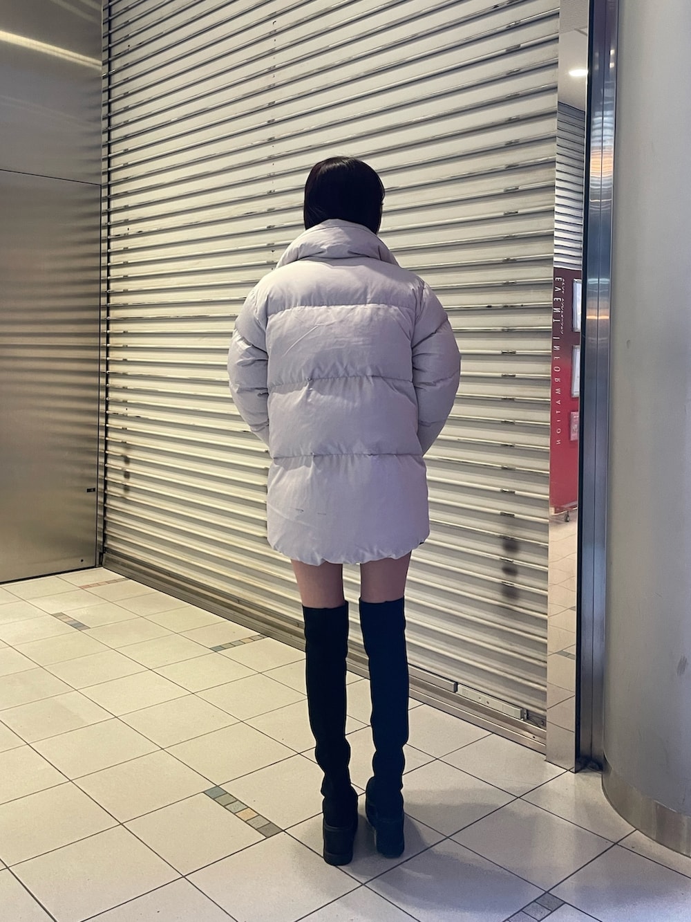 ブラック系のブーツ、ブラック系のニット/セーター、グレー系のダウンジャケット/コートを着用したレディースの冬コーディネートの4枚目の写真