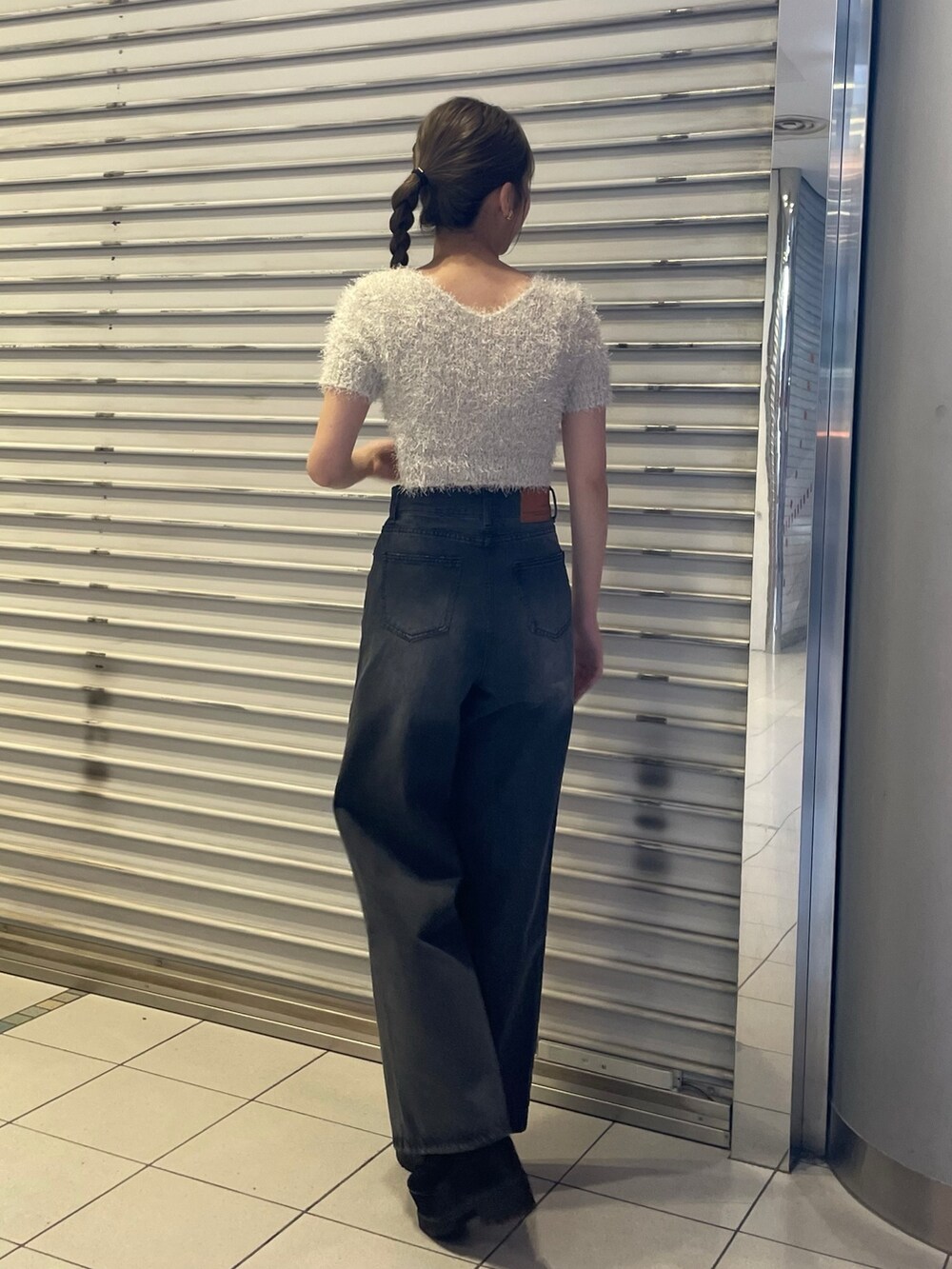 ホワイト系のニット/セーター、ブラック系のデニムパンツ、ブラック系のブーツを着用したレディースの春コーディネートの3枚目の写真