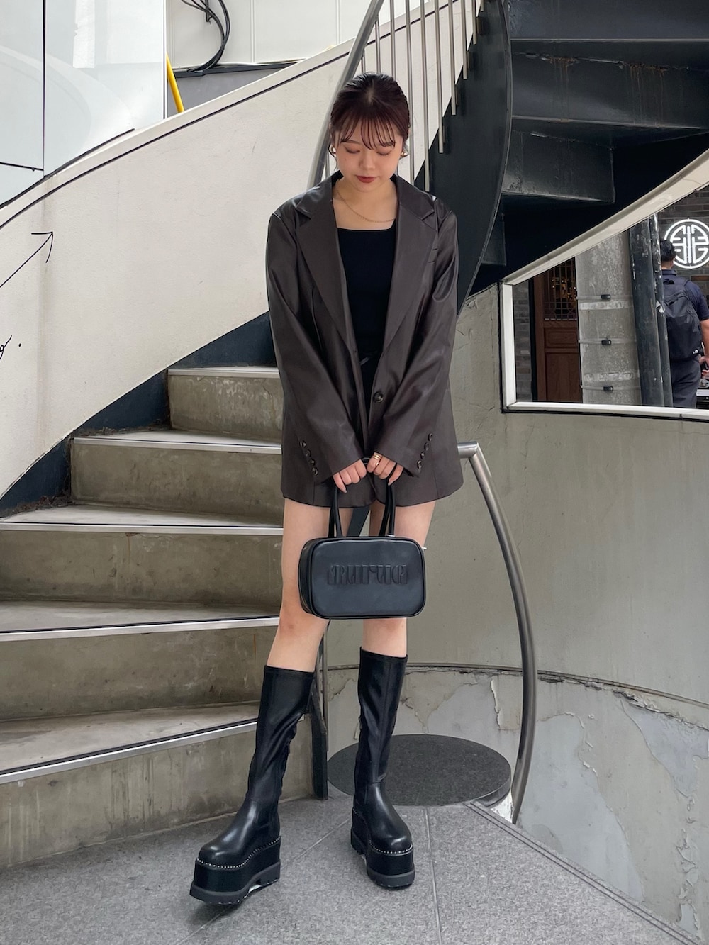 ブラウン系のテーラードジャケット、ブラック系のその他パンツ、ブラック系のブーツを着用したレディースの秋コーディネートの2枚目の写真