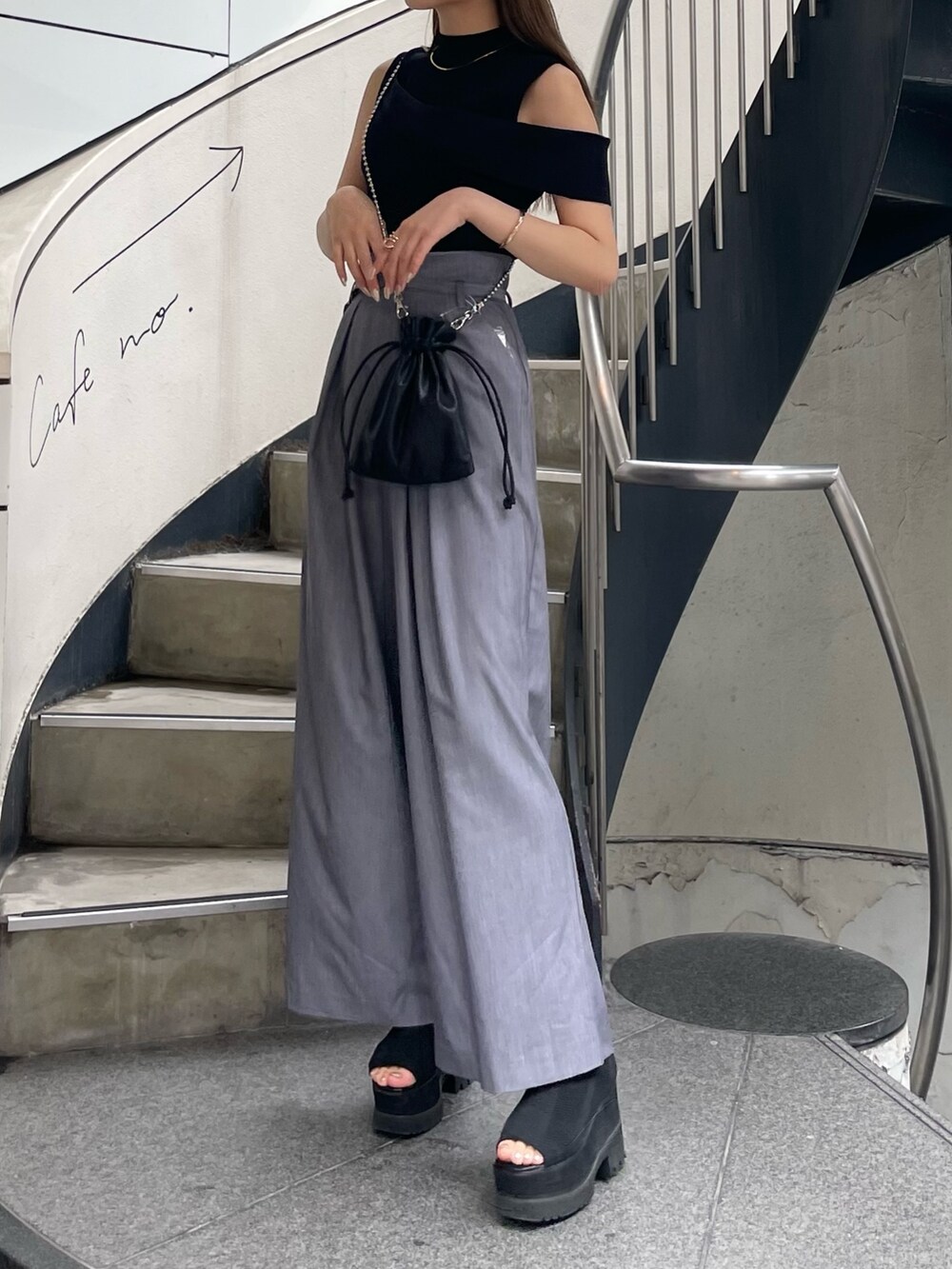 ブラック系のニット/セーター、ブラック系のショルダーバッグ、グレー系のその他パンツを着用したレディースの春コーディネートの4枚目の写真