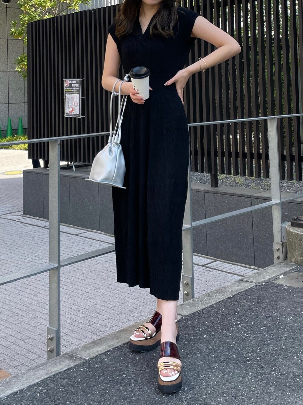 ブラック系のワンピース、シルバー系のハンドバッグ、その他のサンダルを着用したレディースの春コーディネートの5枚目の写真