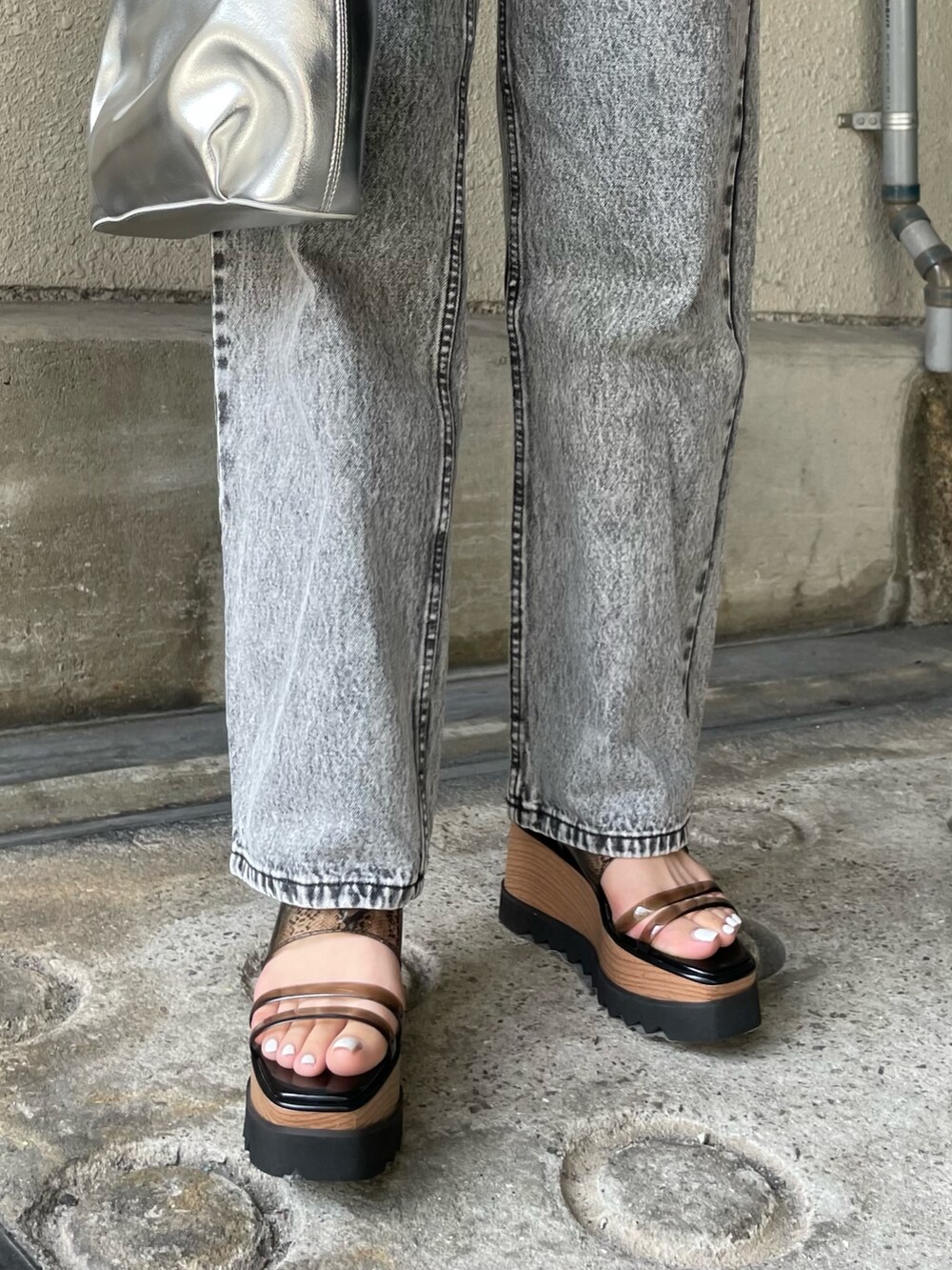 ホワイト系のタンクトップ、シルバー系のハンドバッグ、ブラック系のサンダルを着用したレディースの春コーディネートの8枚目の写真