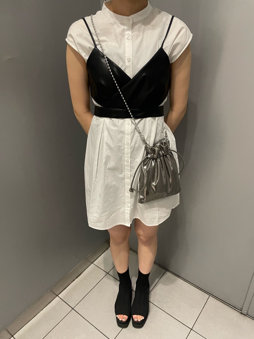 グレー系のショルダーバッグ、ブラック系のブーツ、ブラック系のワンピースを着用したレディースの春コーディネートの7枚目の写真