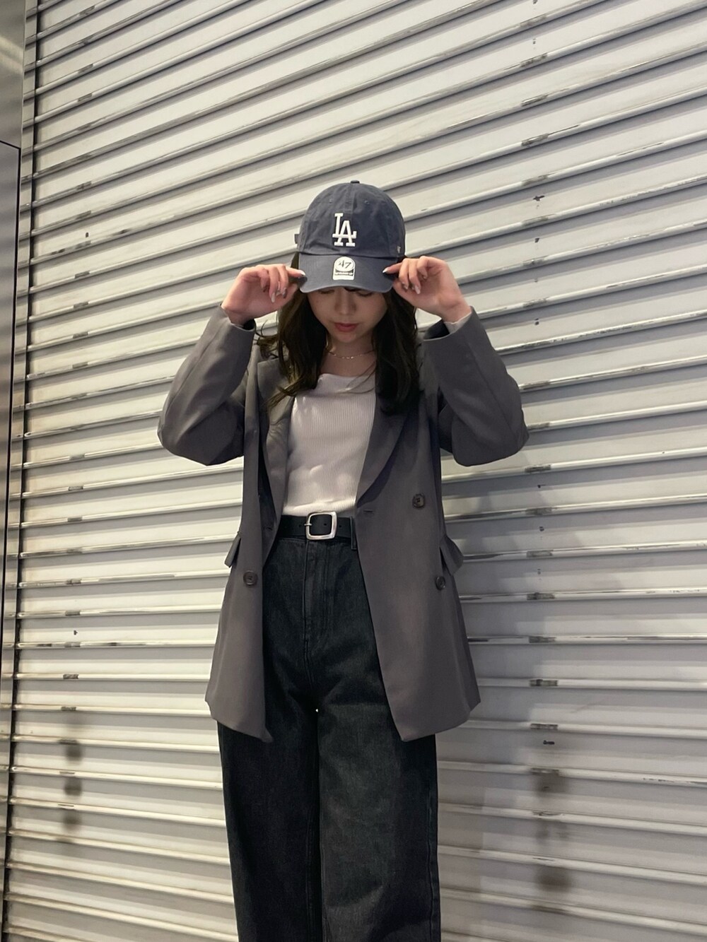 ブラック系のデニムパンツ、グレー系のテーラードジャケット、ホワイト系のニット/セーターを着用したレディースの冬コーディネートの4枚目の写真