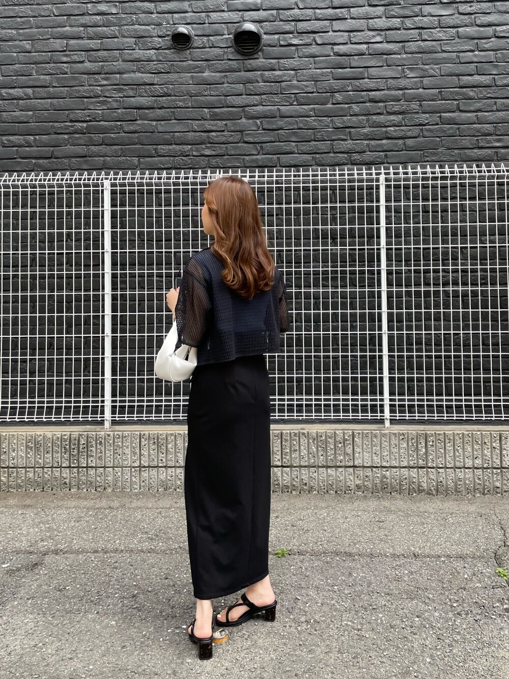 ブラック系のサンダル、ブラック系のスカート、ブラック系のシャツ/ブラウスを着用したレディースの春コーディネートの3枚目の写真
