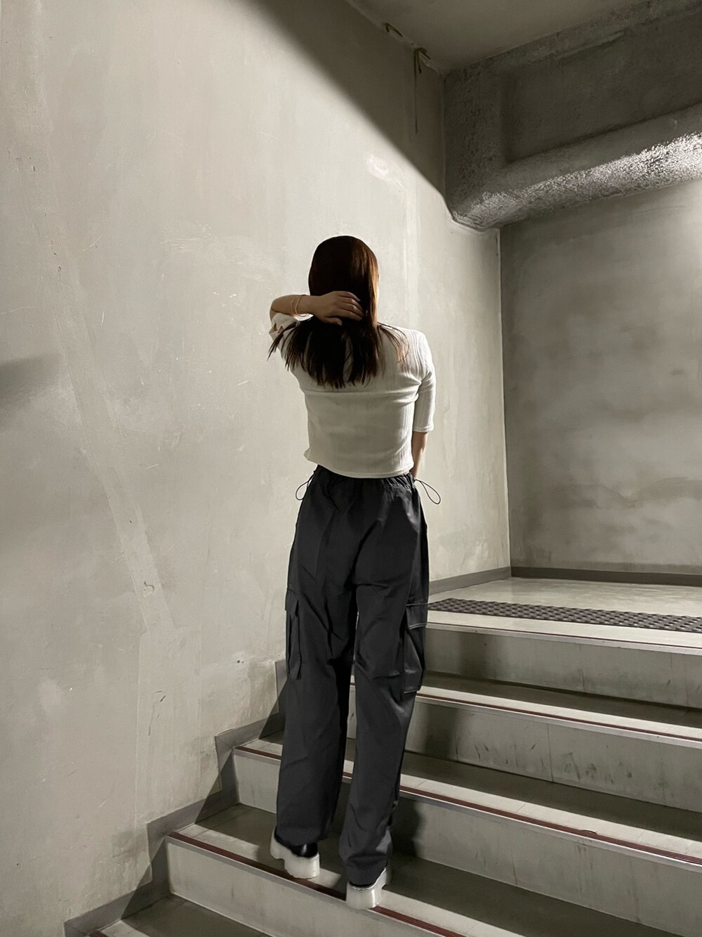 ブラック系のブーツ、ホワイト系のTシャツ/カットソー、グレー系のカーゴパンツを着用したレディースの秋コーディネートの4枚目の写真