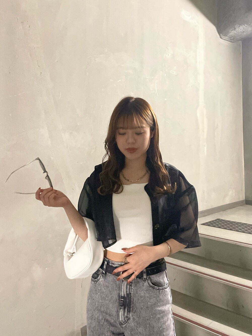 ホワイト系のTシャツ/カットソー、グレー系のデニムパンツ、ブラック系のサンダルを着用したレディースの春コーディネートの5枚目の写真