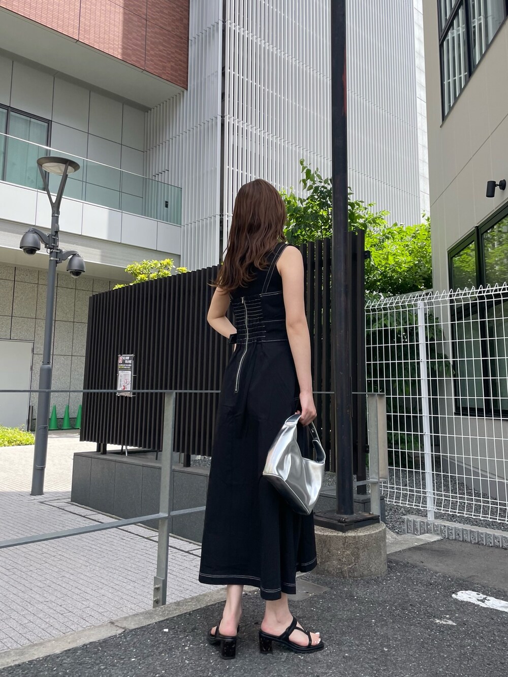 ブラック系のワンピース、ブラック系のニット/セーター、シルバー系のハンドバッグを着用したレディースの春コーディネートの3枚目の写真