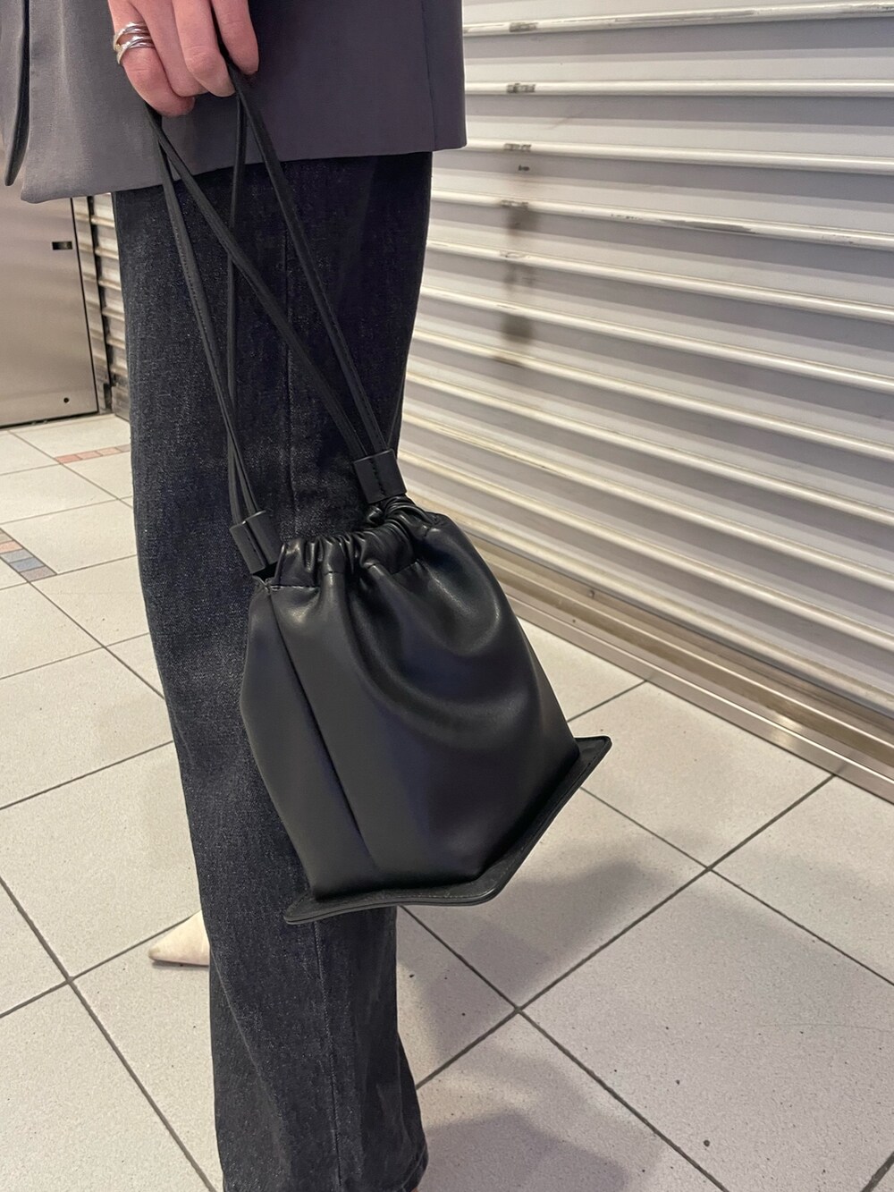 ブラック系のデニムパンツ、グレー系のテーラードジャケット、ホワイト系のニット/セーターを着用したレディースの冬コーディネートの7枚目の写真