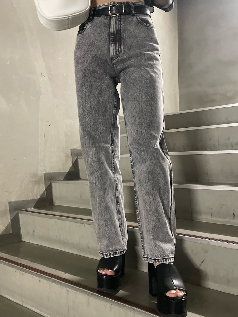 ホワイト系のTシャツ/カットソー、グレー系のデニムパンツ、ブラック系のサンダルを着用したレディースの春コーディネートの7枚目の写真