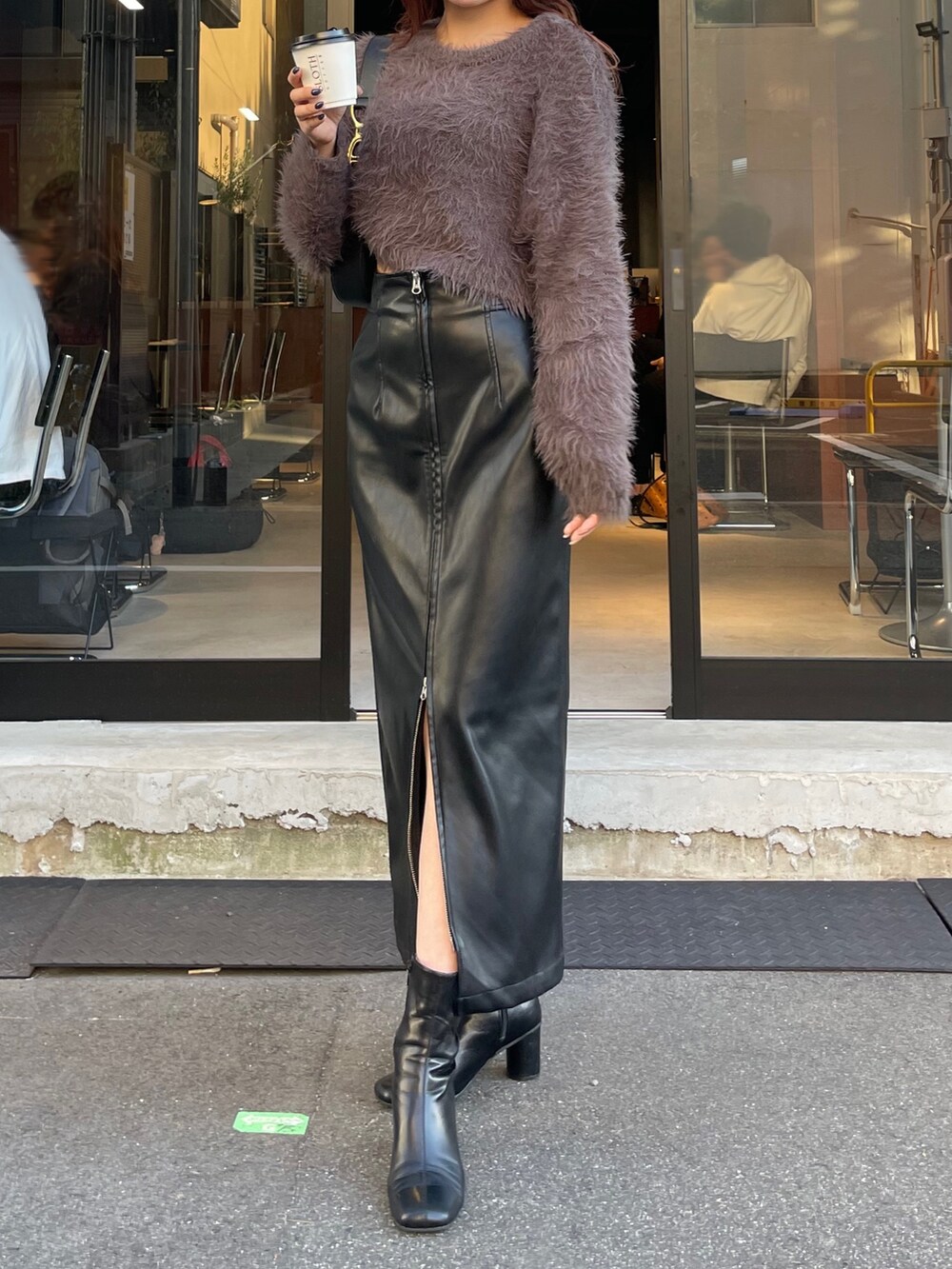 ブラック系のスカート、ブラック系のブーツ、グレー系のニット/セーターを着用したレディースの秋コーディネートの2枚目の写真