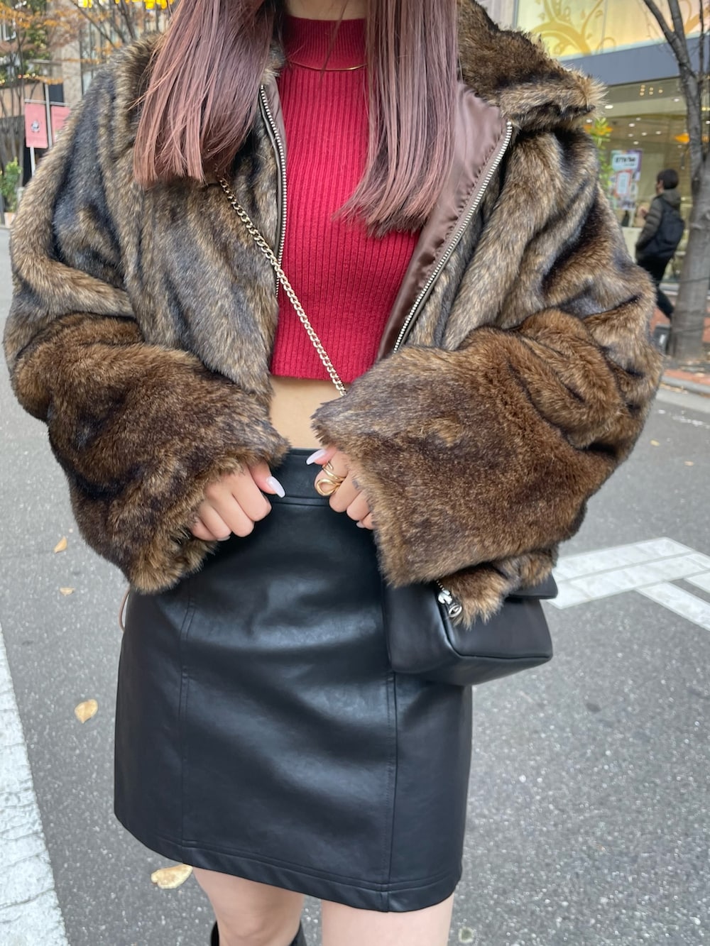 ブラック系のブーツ、ブラック系のスカート、レッド系のニット/セーターを着用したレディースの冬コーディネートの5枚目の写真