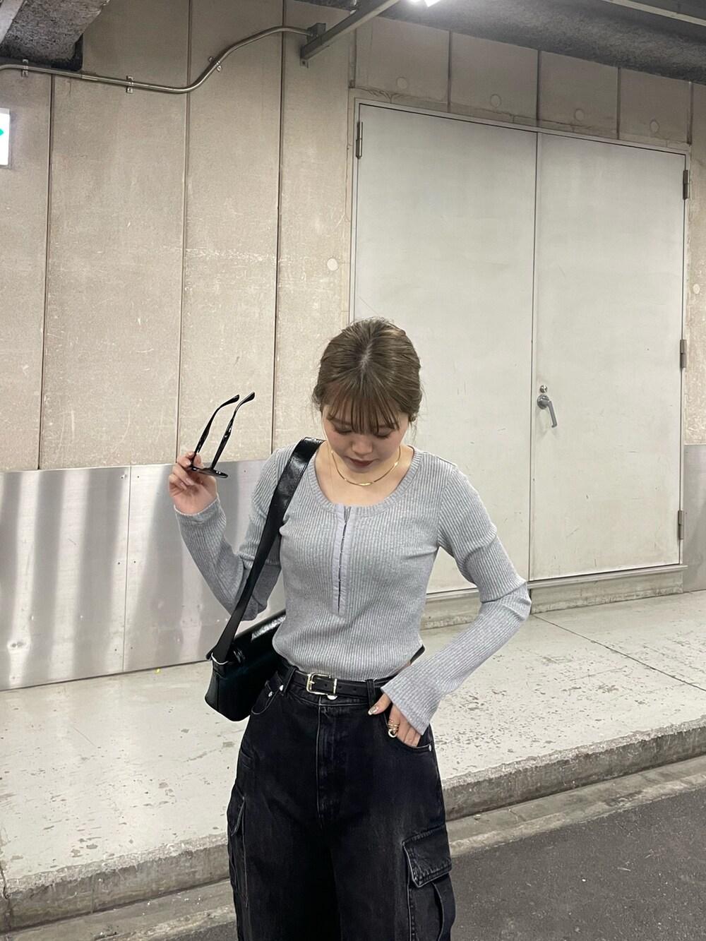 ブラック系のデニムパンツ、ブラック系のショルダーバッグ、グレー系のTシャツ/カットソーを着用したレディースの冬コーディネートの5枚目の写真