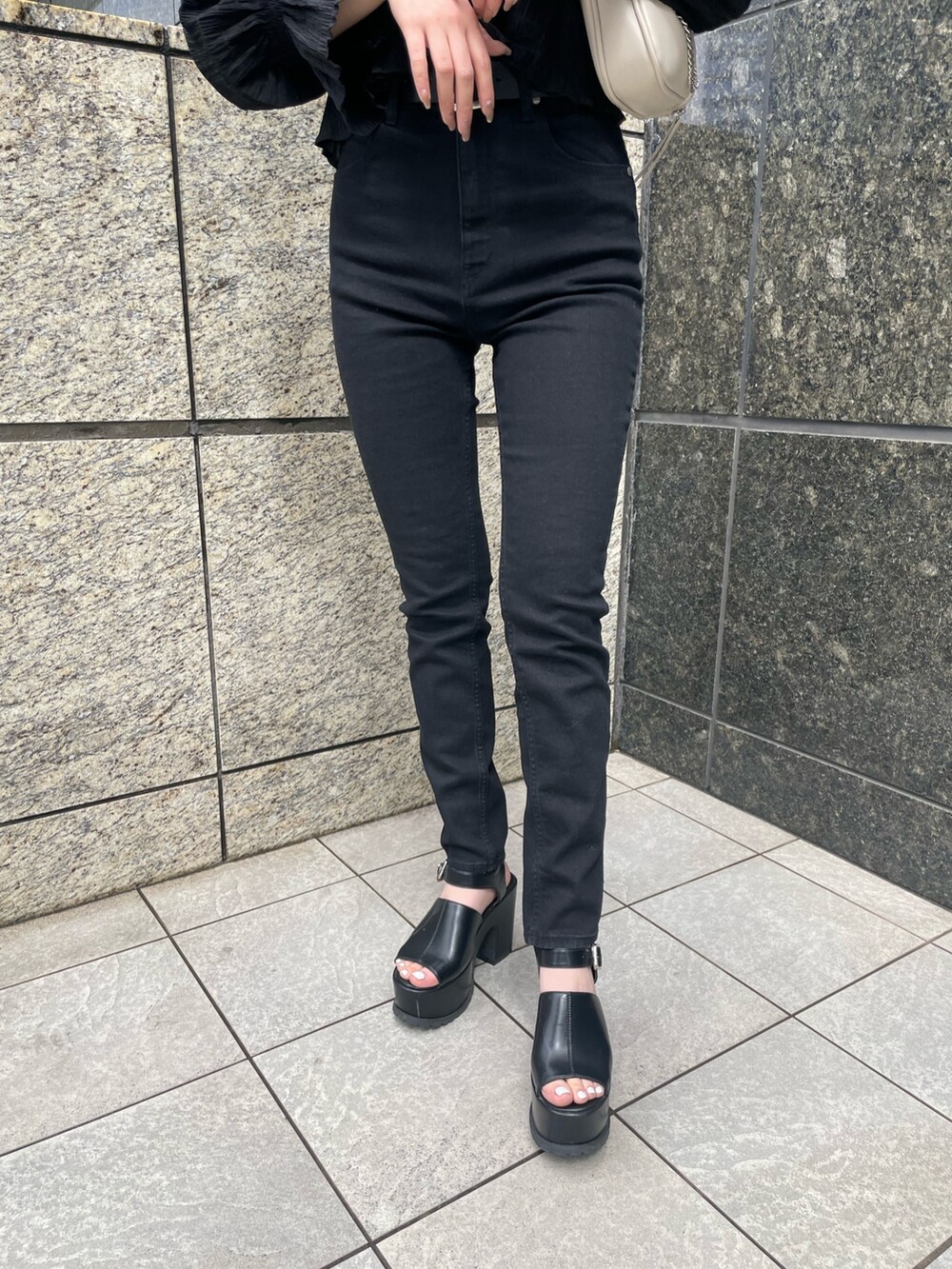 ブラック系のデニムパンツ、ブラック系のサンダル、ブラック系のシャツ/ブラウスを着用したレディースの春コーディネートの6枚目の写真