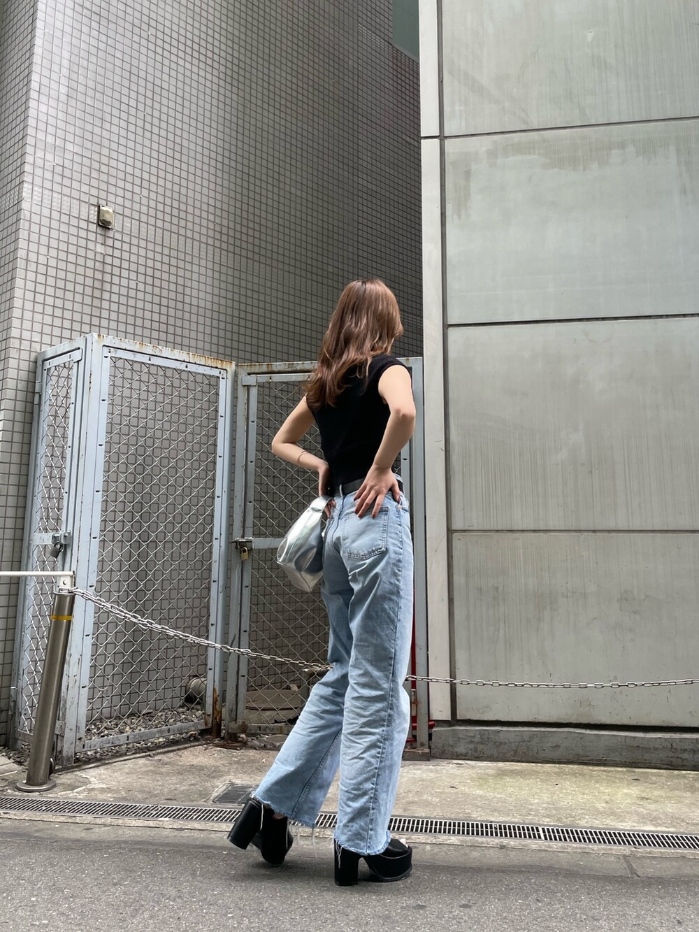 ブラック系のニット/セーター、シルバー系のハンドバッグ、ブラック系のサンダルを着用したレディースの春コーディネートの4枚目の写真