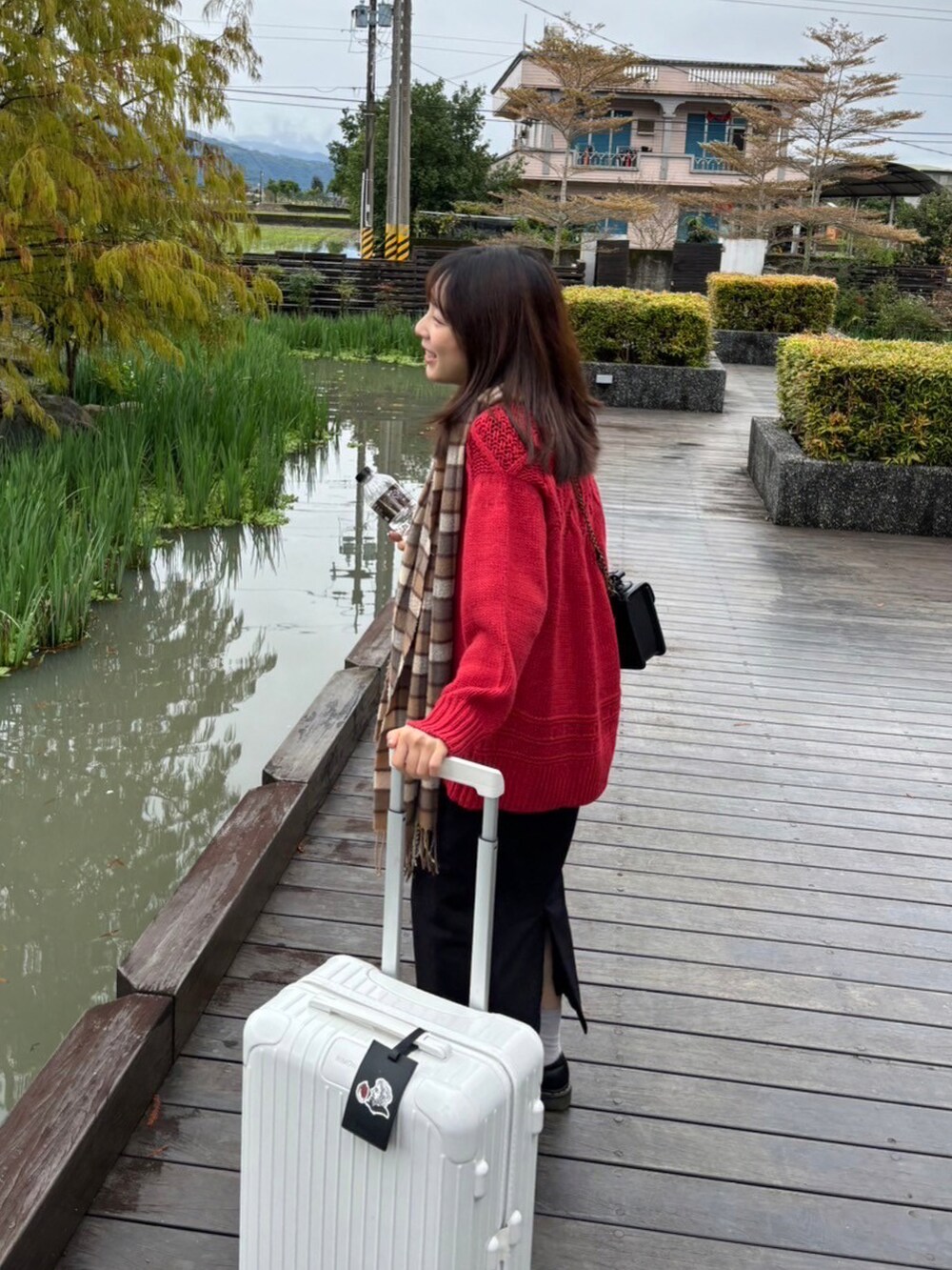 ブラック系のスカート、レッド系のニット/セーター、ブラック系のローファーを着用したレディースの秋コーディネートの2枚目の写真